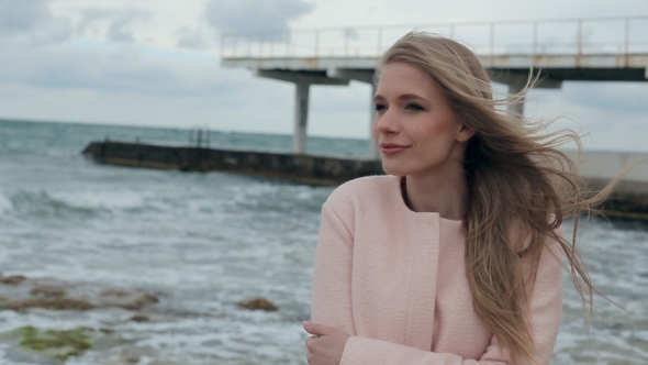 Happy Girl In a Pink Coat Near The Sea 