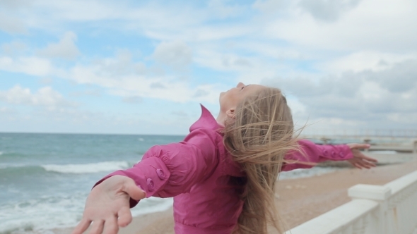 Blonde Girl Raises Her Arms Up On The Beach alt