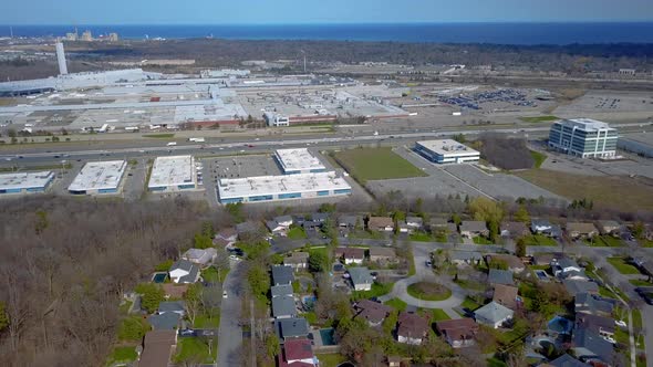 Aerial over a highway, neighbourhood and industrial park in Oakville, Ontario, Canada. alt