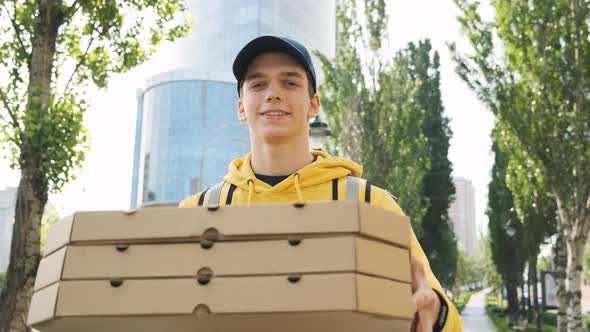 Portrait of Young Attractive Caucasian Delivery Man Standing with Pizza Boxes and Backpack Looking alt