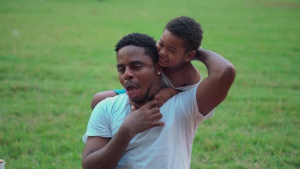 African American father and son playing in park, parent and childs play in park