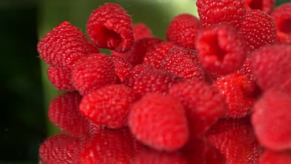 Super Slow Motion Shot of Fresh Raspberries Falling on Reflective Background at 1000Fps alt