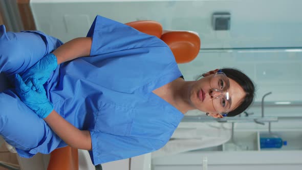Vertical Video Dental Assistant Looking at Camera Speaking with Patients alt