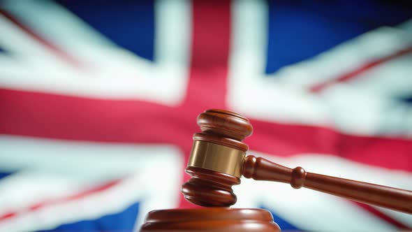 A Judge Gavel with a Flag of United Kingdom on Background alt