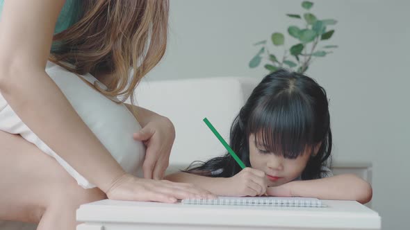 An Asian Mother Teaching Her Daughter at Home 03 alt