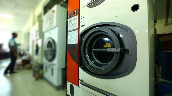 Worker Checks Washing Machines In Laundry Room
