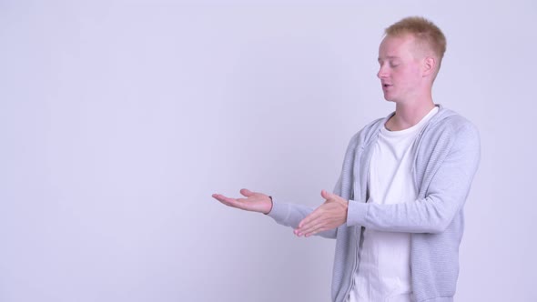 Happy Young Blonde Handsome Man Presenting Something