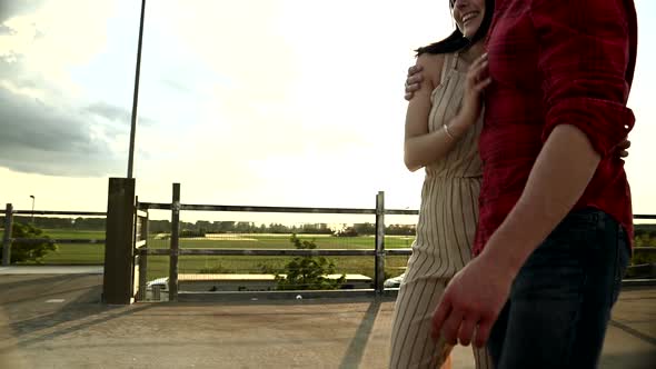Young couple walking on parking deck alt