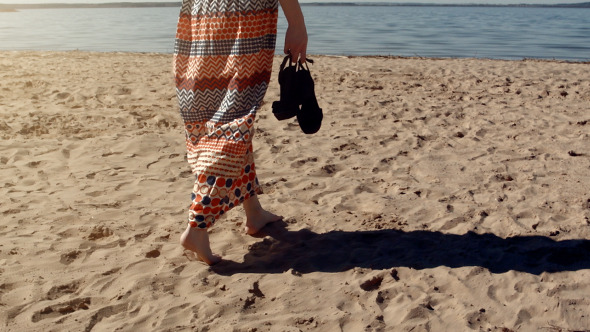 Young Woman Walking On The Sand On Sea Beach
