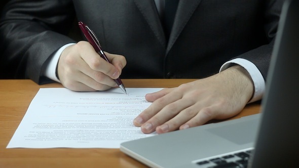 Signature Of The Contract And Typing On Laptop