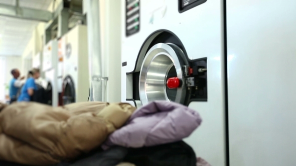 Worker Loads Dirty Clothes In Washing Machine