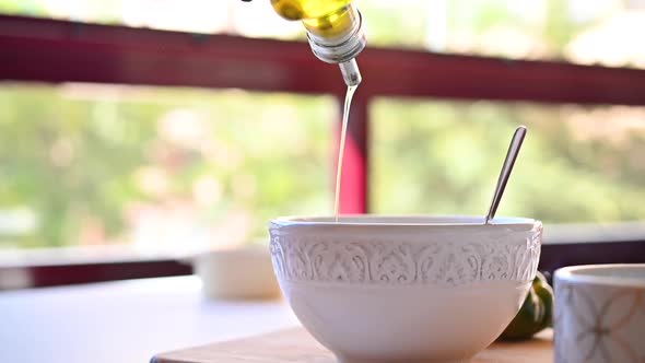 Olive Oil is Poured Into a White Cup