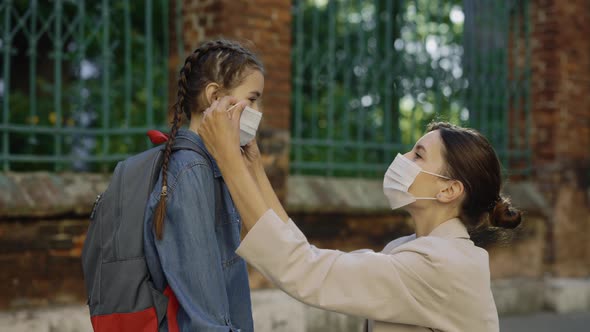 Mother Carrying About Her Kid and Wearing the Surgery Mask to Her Daughter on the Street Before alt