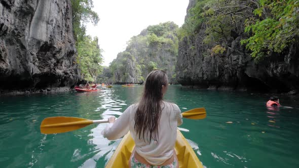 Young brown haired caucasian woman kayaking in beautiful Small Lagoon in El Nido, Palawan, the Phili alt