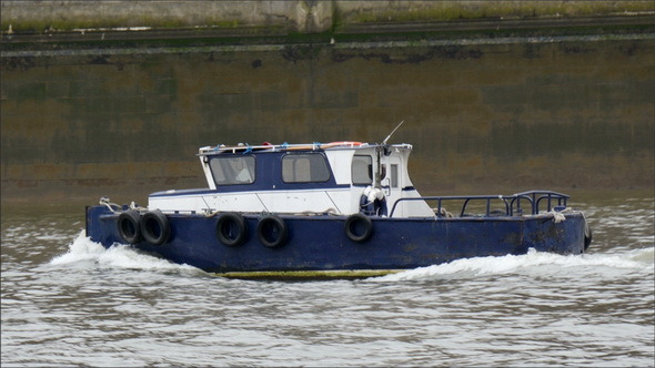 A Blue Small Ferry Boat Crossing the Thames River