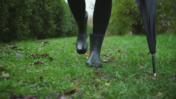 Woman In Boots Walking Through Grass