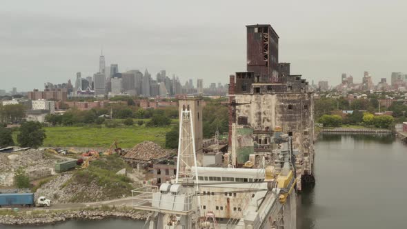 Over Old Rusty Cargo Ship Crane and Warehouse with New York City Skyline in Background on a alt
