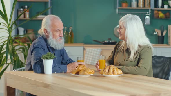An Affectionate Elderly Couple Is Having Breakfast in The Cozy Kitchen alt