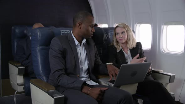 Business people working on airplane flight