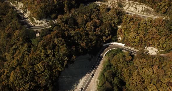 Aerial View of Car Driving Along The Winding Mountain Pass Road Through The Forest Trees. Autumn alt