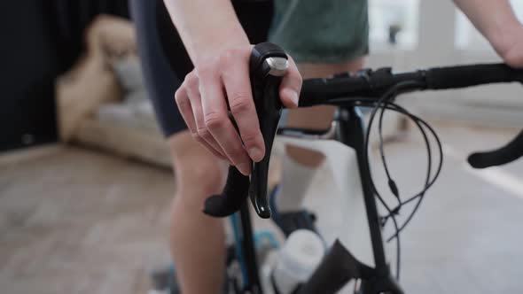 Close Shot of a Cyclist Changing Speed on an Exercise Bike Training at Home