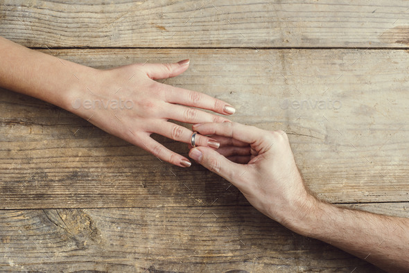 Man putting on an engagement to his woman. - Stock Photo - Images