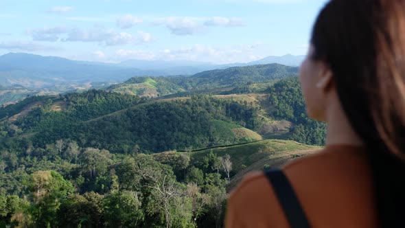 Blurred of a female traveler looking at a beautiful green mountains view