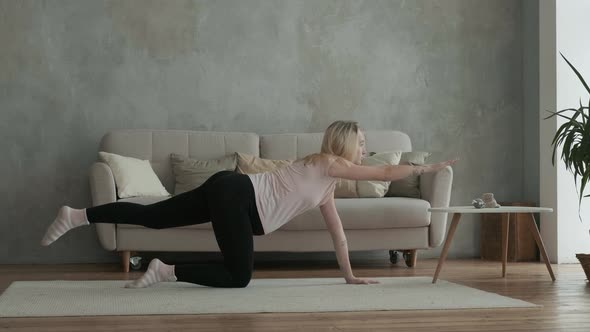Pregnant woman doing yoga in the room