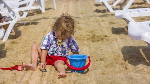 Child Playing With Toys In Sand 