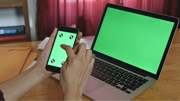 Girl Using Phone with Laptop Green Screen alt