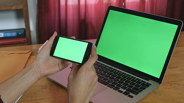 Girl Holding Smartphone with Green Screen laptop