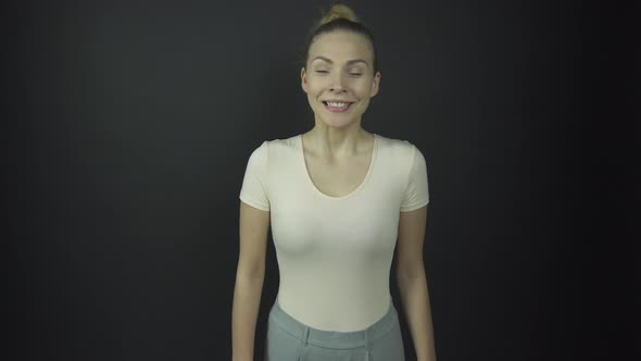 Excited Beautiful Lady with Fair Hair Stands and Claps Hands alt