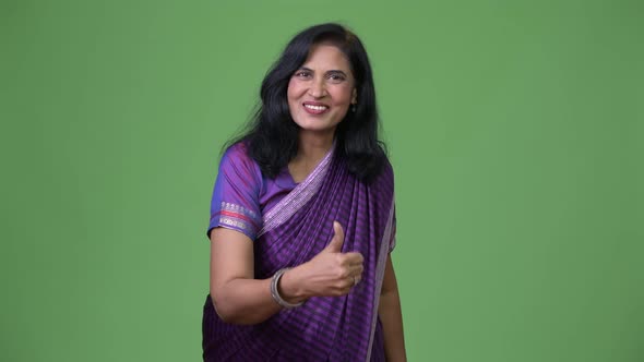 Mature Happy Beautiful Indian Woman Giving Thumbs Up While Wearing Sari Traditional Clothes alt