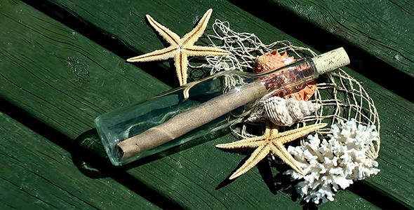 Sea Shells and Message Bottle on Wood Pier