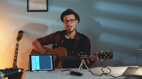 Handsome Boy in Hat Recording His New Track in Home Studio alt