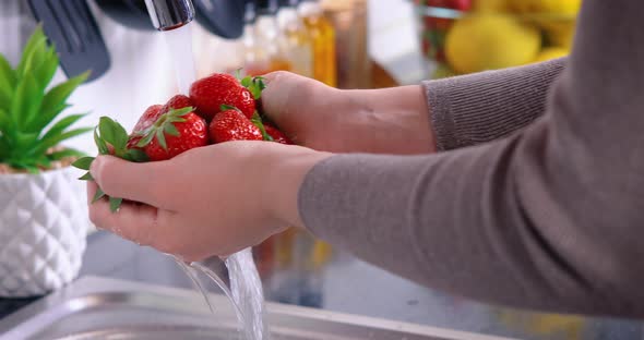 Woman Washing Strawberries in the Kitchen