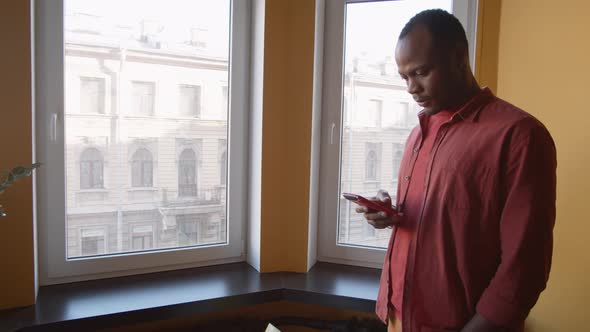 African American Man Using Smartphone in Office Breakout Area alt