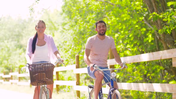 Happy Couple Riding Bicycles at Summer Park alt