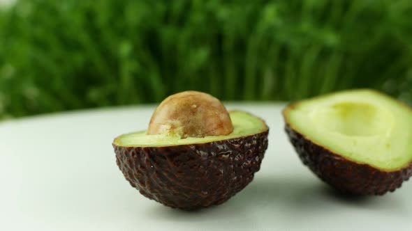 Avocado rotates on a green grass background. 4K video close-up of wholesome and healthy food