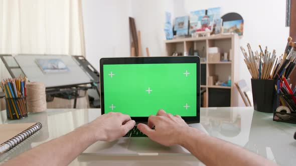 Designers Point of View Working on a Laptop with Green Screen on alt