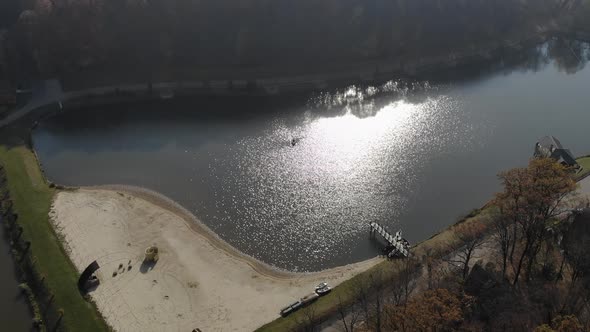 Aerial Shot of Brides Swim in a Red Boat. The Bright Sun Is Reflected in the Lake Creating a alt
