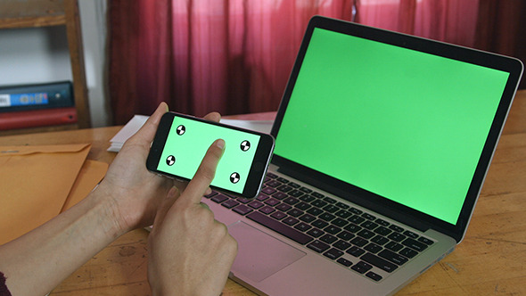 Girl Using her Phone with Green Screen Laptop