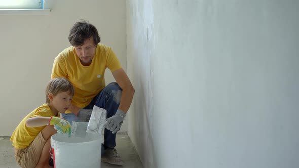 A Young Man and His Son are Doing a Walls Renovation in Their Home alt
