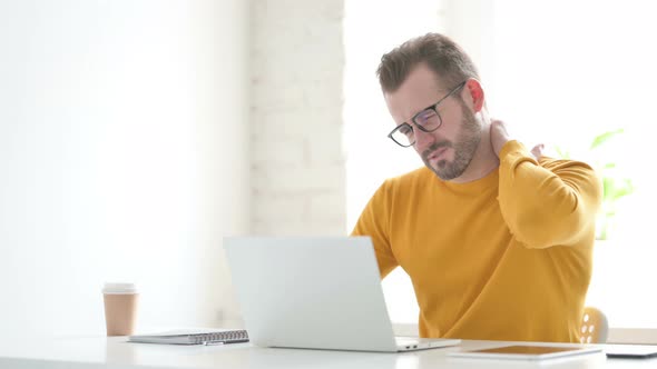 Man Having Neck Pain While Using Laptop in Office alt