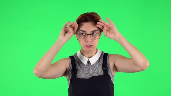 Portrait of Funny Girl in Glasses Is Cooling Herself By Her Hand, Suffering From High Temperature alt