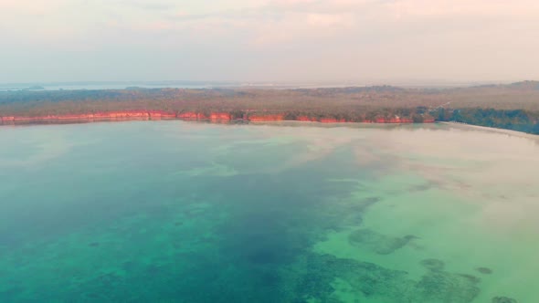 Aerial: uncontaminated coastline beach sunset Kei Islands Maluku Indonesia alt