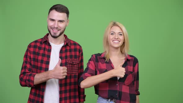 Young Couple Giving Thumbs Up Together