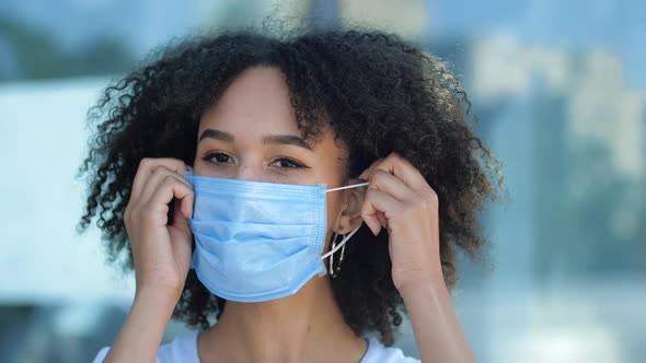 Beautiful Smiling Young African American Woman Takes Off Protective Medical Mask From Face, Breathes alt