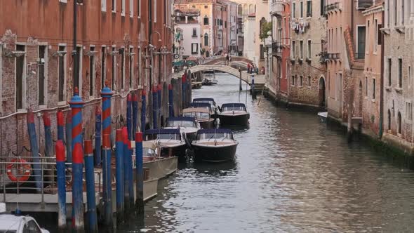 Narrow Canals of Venice with Gondolas Parked on Water Between Colorful Houses alt