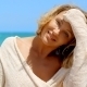 Blond Woman With Hand In Hair Sitting On Beach - VideoHive Item for Sale